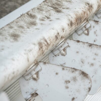 up close view of air conditioning unit with dust and mold attached to fan