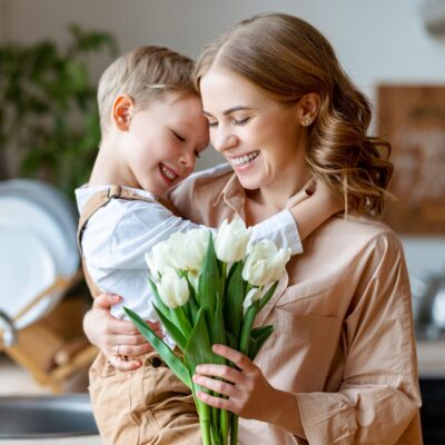 mom and son smelling bouquet of flowers in their kitchen